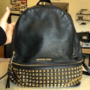 Michael Kora black leather backpack with triangular gold studs and hardware.